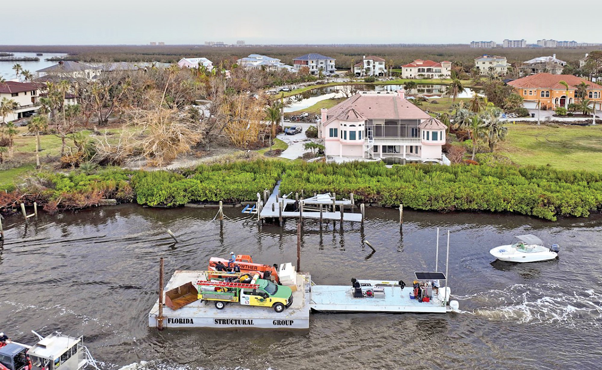 Vehicles for Crowther Roofing & Cooling travel via barge to Sanibel before temporary repairs were made to reopen parts of the causeway to the island washed away by Hurricane Ian. COURTESY PHOTOS