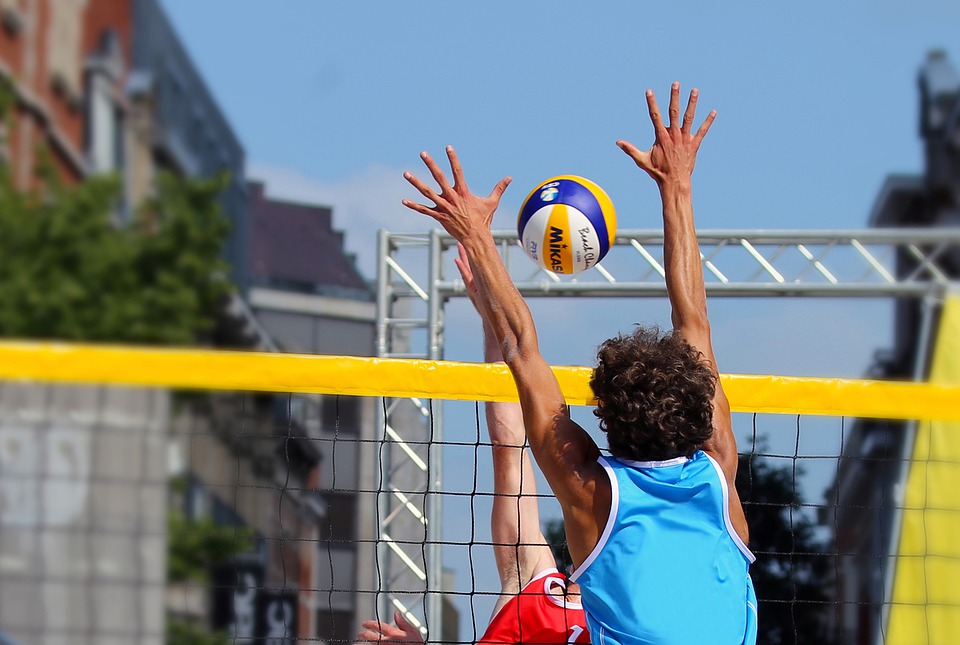 A person hitting a volleyball over a net